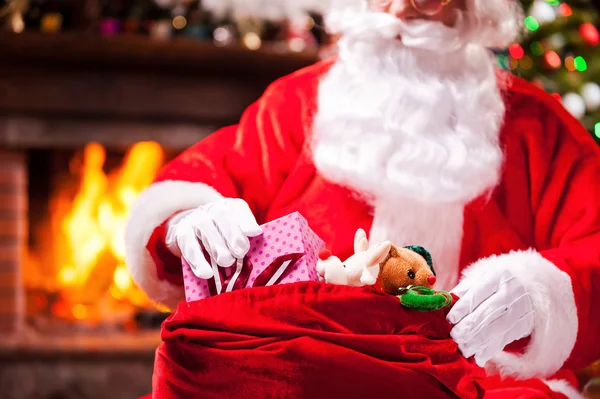 Santa Claus packing Christmas presents — Stock Photo, Image