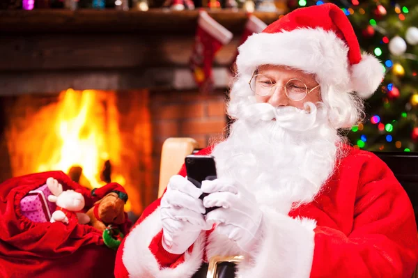 Noel Baba tipik haber üstünde hareket eden telefon — Stok fotoğraf