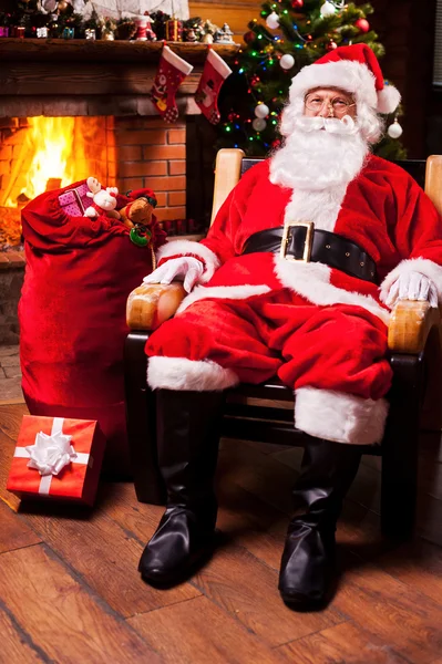 Santa Claus sentado en su silla de madera — Foto de Stock