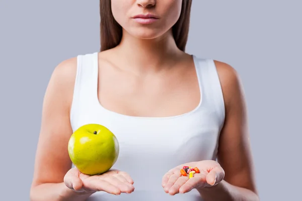 Woman holding apple and pills — Stock Photo, Image