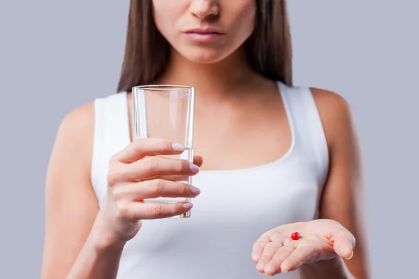 Mujer sosteniendo vidrio con agua y pastillas — Foto de Stock