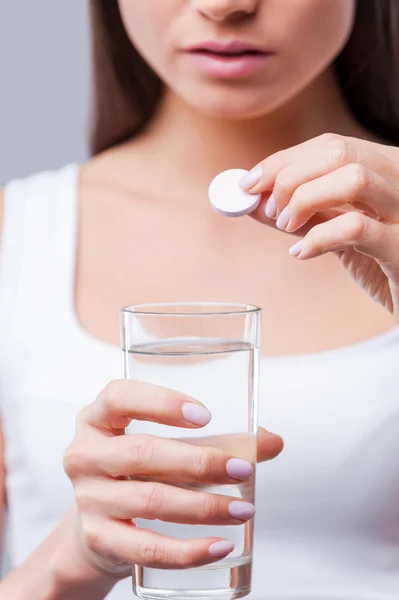 Woman holding glass of water and pill — Stock Photo, Image