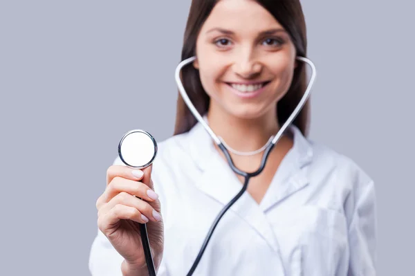 Doctor en uniforme blanco sosteniendo estetoscopio — Foto de Stock