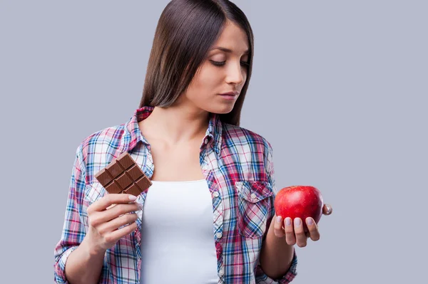 Mulher segurando uma maçã e barra de chocolate — Fotografia de Stock