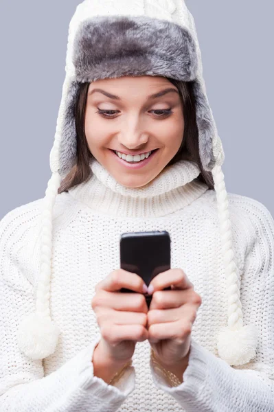 Женщина в зимней одежде держит телефон — стоковое фото