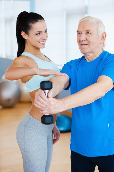 Physical therapist helping senior man with fitness — Stock Photo, Image