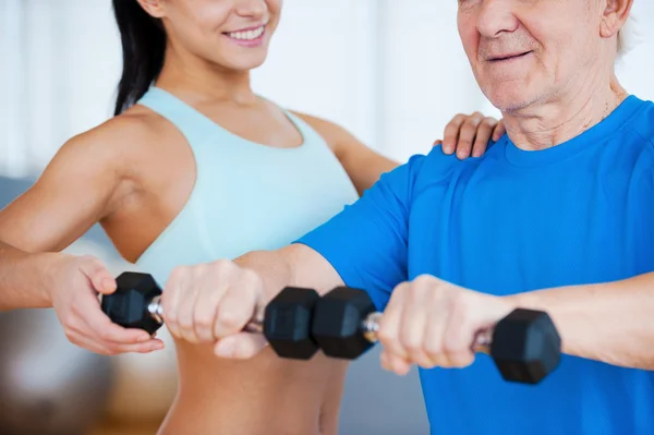 Physical therapist helping senior man with fitness — Stock Photo, Image