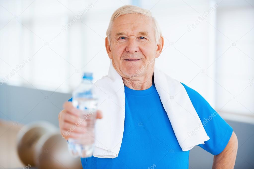 Hombre mayor con toalla y botella con agua — Foto de stock