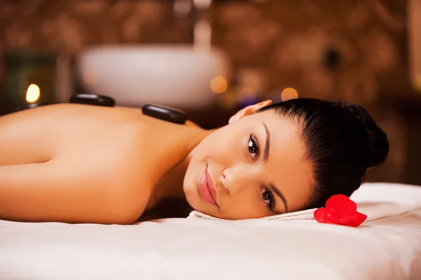 Woman lying with spa stones on back — Stock Photo, Image