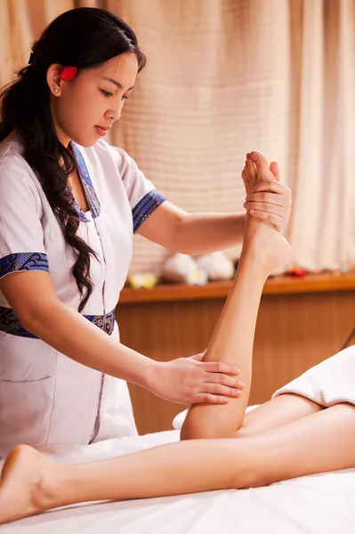Tailandês massagem terapeuta massageando perna feminina — Fotografia de Stock
