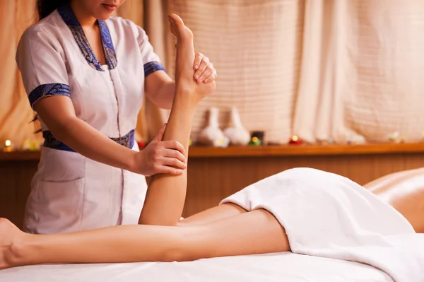 Massagista massageando a perna feminina — Fotografia de Stock