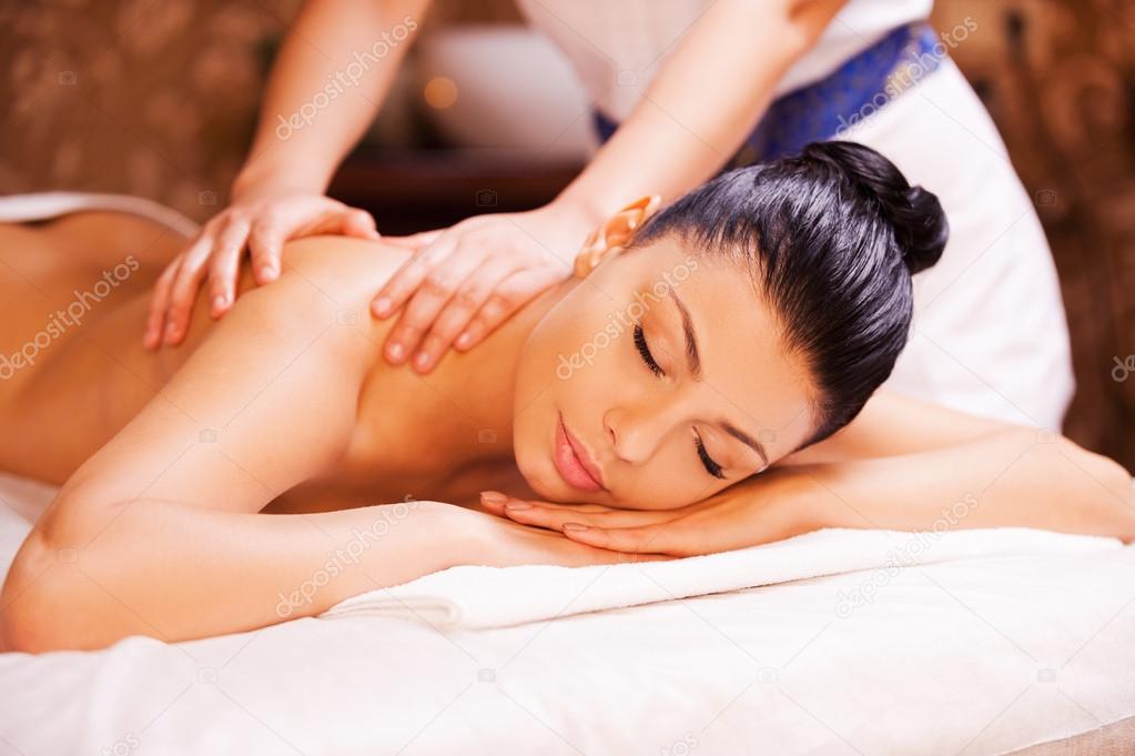 Massage therapist massaging woman back