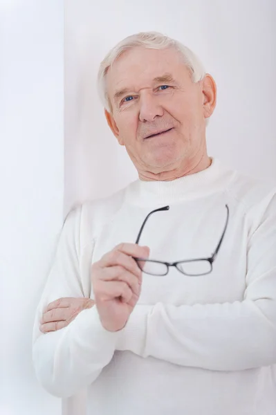 Senior homem segurando óculos — Fotografia de Stock