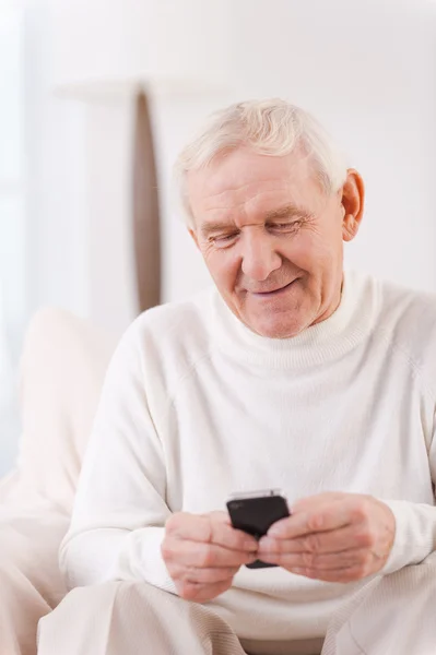 Старший чоловік тримає мобільний телефон — стокове фото