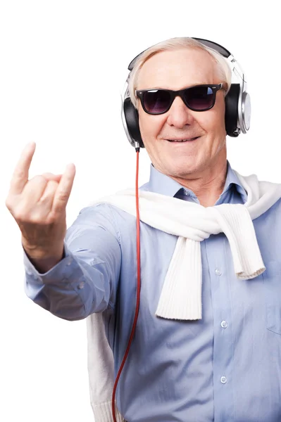 Старший в наушниках слушает музыку — стоковое фото