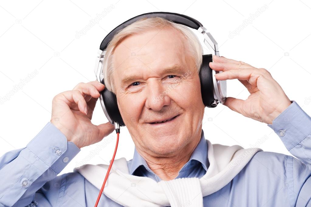 senior man in headphones listening to music stock photo