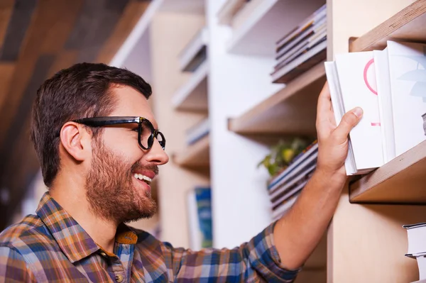 Man choosing book from bookshelf — Stock Photo, Image