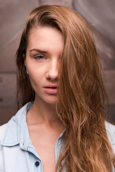 Frau im Hemd bedeckt Hälfte ihres Gesichts durch Haare — Stockfoto