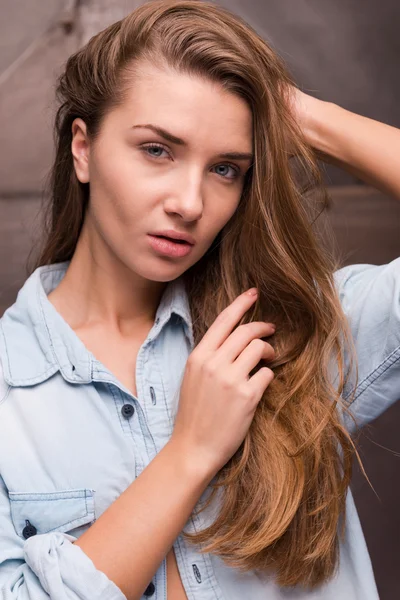 Wanita dalam kemeja berpegangan tangan di rambut — Stok Foto