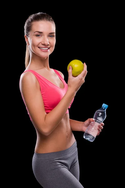 Frau hält Apfel und Flasche mit Wasser — Stockfoto