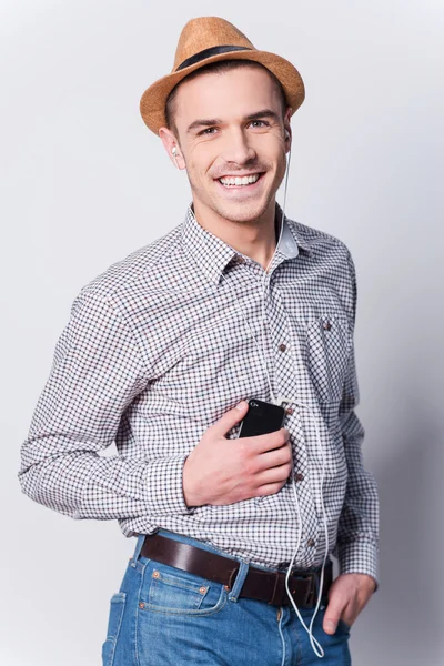 Man in fedora listening to MP3 player — Stock Photo, Image