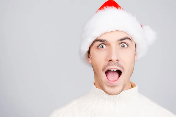 Surprised young man in Santa hat — Stock Photo, Image