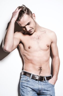 Genç gömleksiz adam kot pantolon