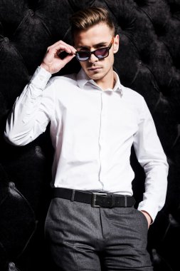 Yakışıklı genç adam güneş gözlüğü ayarlama