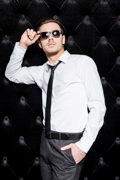Hombre con camisa y corbata ajustando sus gafas de sol — Foto de Stock