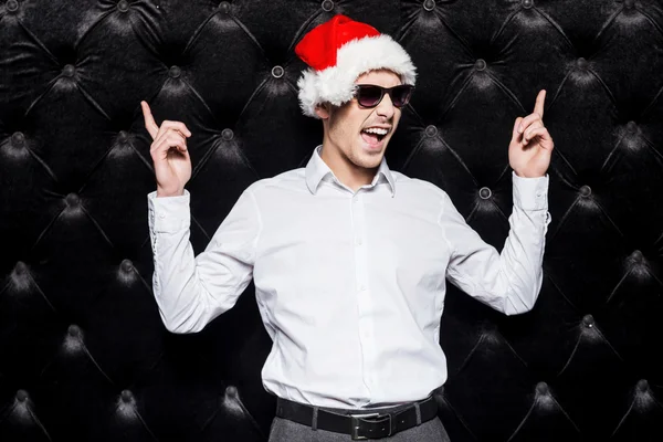 Man in sunglasses and Santa hat pointing up — Stock Photo, Image