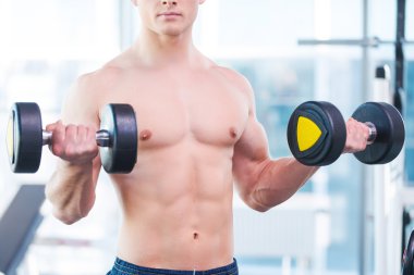 Halterle egzersiz yapan kaslı bir adam.