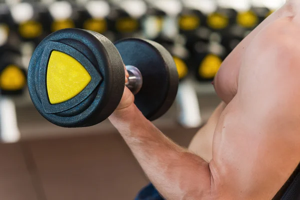 Uomo muscolare che si esercita con i manubri — Foto Stock