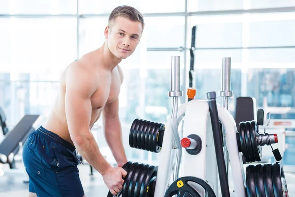 Uomo muscolare scegliere il peso per sollevare — Foto Stock