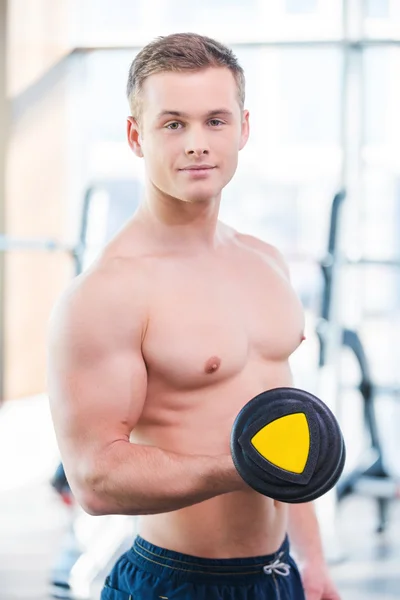 Homem musculoso treinando com halteres — Fotografia de Stock