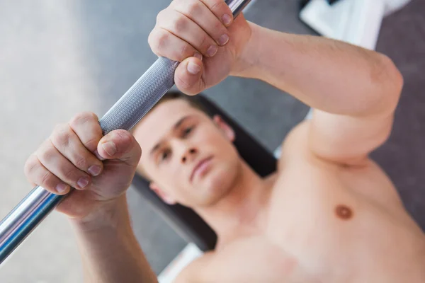 Musculoso hombre haciendo ejercicio en press de banca — Foto de Stock