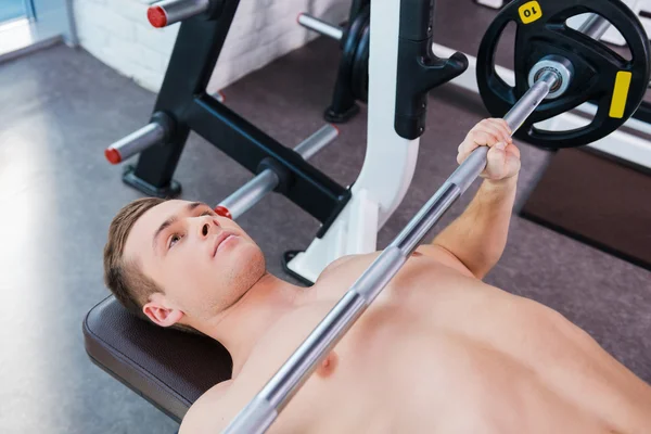 Gespierde man uit te werken op bankdrukken — Stockfoto