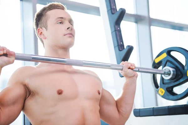 Muskulöser Mann trainiert beim Bankdrücken — Stockfoto