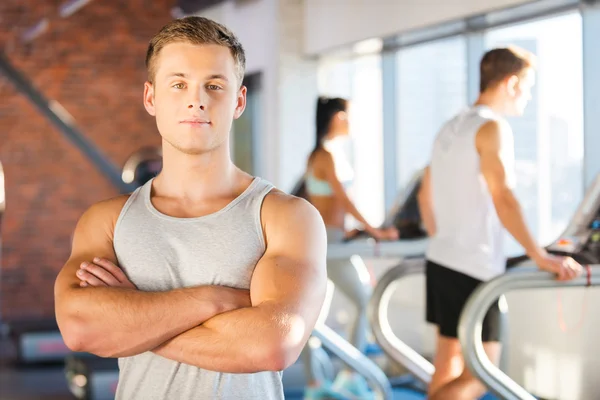 Man houden gekruiste armen en mensen lopen door loopband — Stockfoto