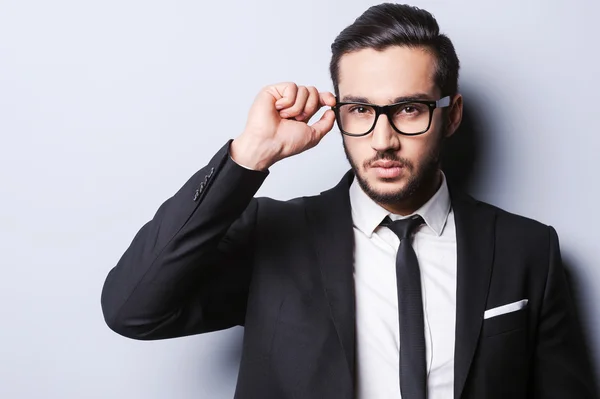 Hombre en ropa formal ajustando sus gafas — Foto de Stock