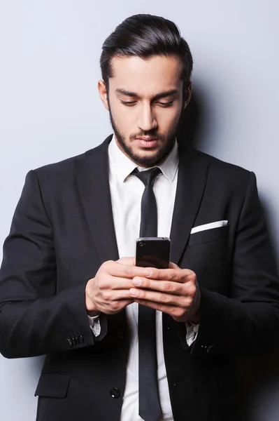 Giovane uomo in abbigliamento formale in possesso di telefono cellulare — Foto Stock