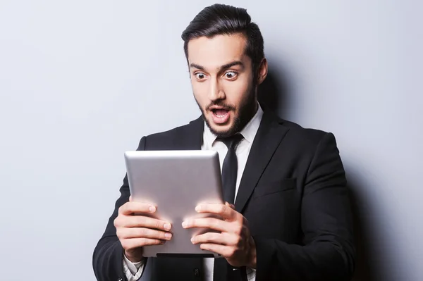 Zaskoczony mężczyzna trzyma cyfrowy tablicowy — Zdjęcie stockowe