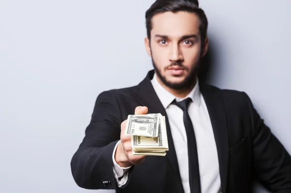 Man in formalwear stretching out money — Stock Photo, Image