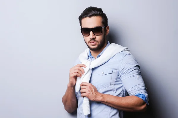 Man in blue shirt tying sweater on shoulders — Stock Photo, Image