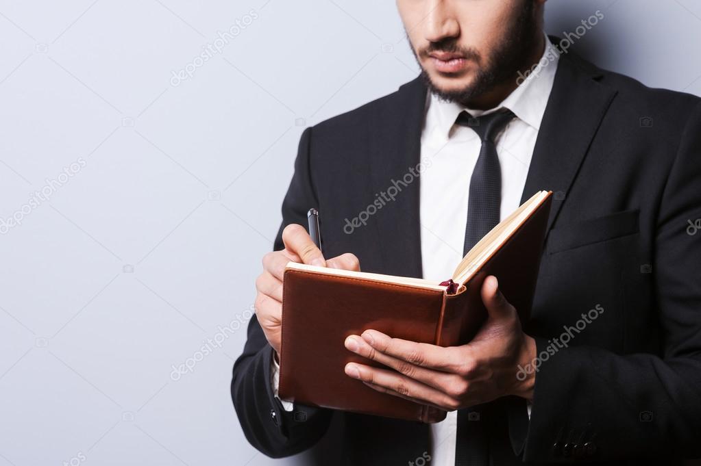Man in formalwear holding note pad