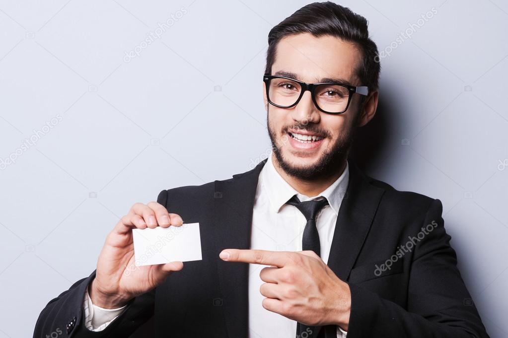 Man in formalwear stretching out business card