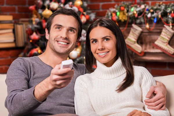 Любящая пара смотрит телевизор на Рождество — стоковое фото