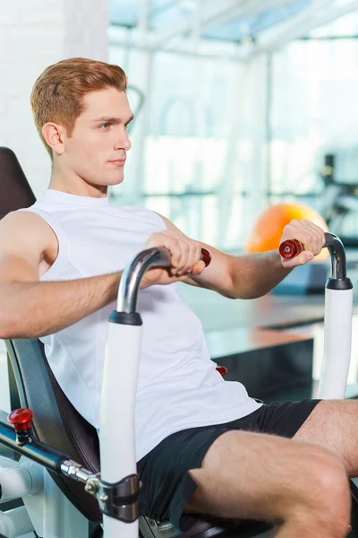 Spor salonunda egzersiz genç adam — Stok fotoğraf