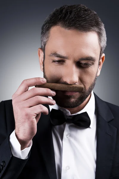 Mature man in formalwear smelling cigar — Stock Photo, Image