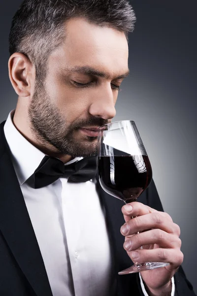 Man in formalwear smelling red wine — Stock Photo, Image