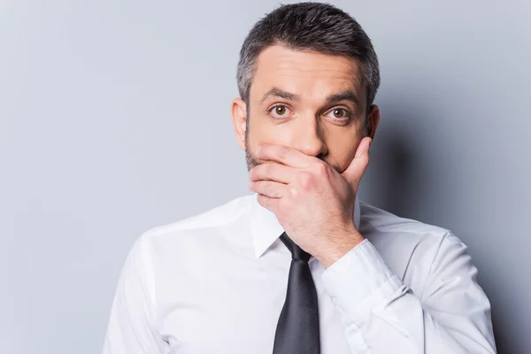 Man in shirt and tie covering mouth with hand — Stock Photo, Image